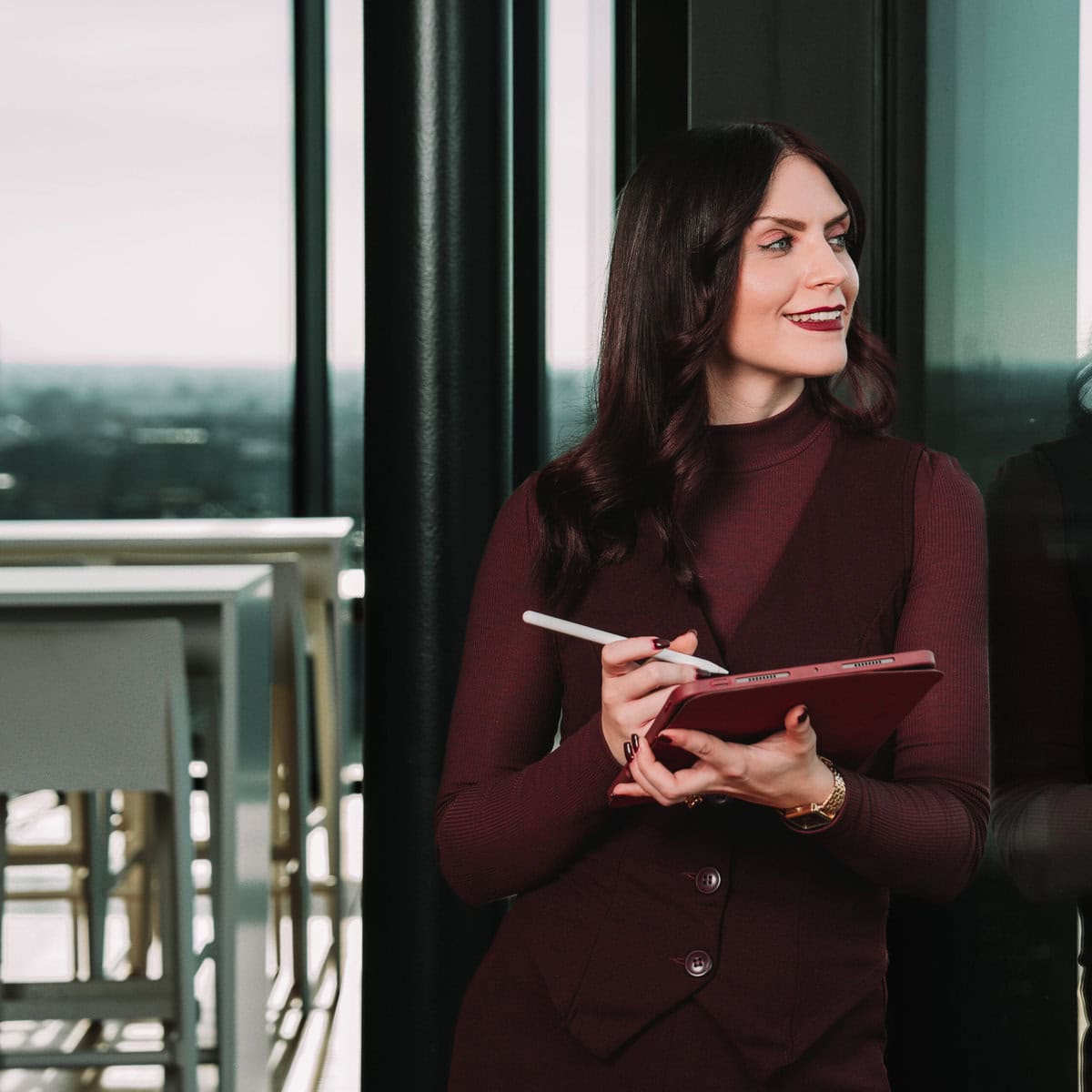 Kristina Heisler arbeitet am Tablet und schaut lächelnd nach links